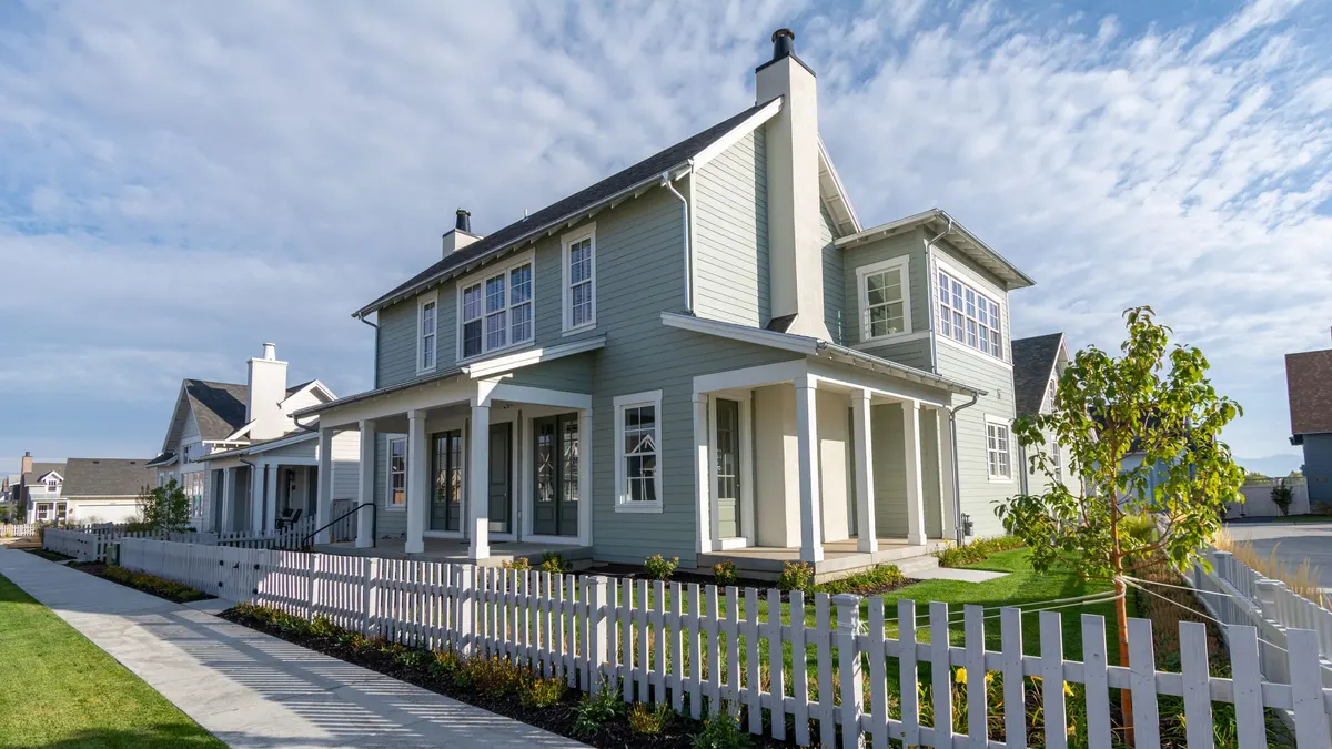 Newer two-story homes with white picket fences along a sidewalk