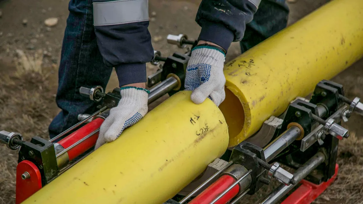 Yellow HDPE pipe held in a fusion machine before installation