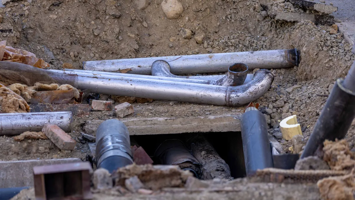 Pipes in a small access pit dug in the ground